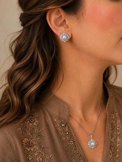 Woman wearing a pearl and crystal floral necklace set with matching stud earrings, styled with a mocha embroidered outfit and soft waves.