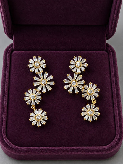 Gold Bloom Cascade floral cubic zirconia drop earrings displayed inside a premium plum velvet jewellery box.