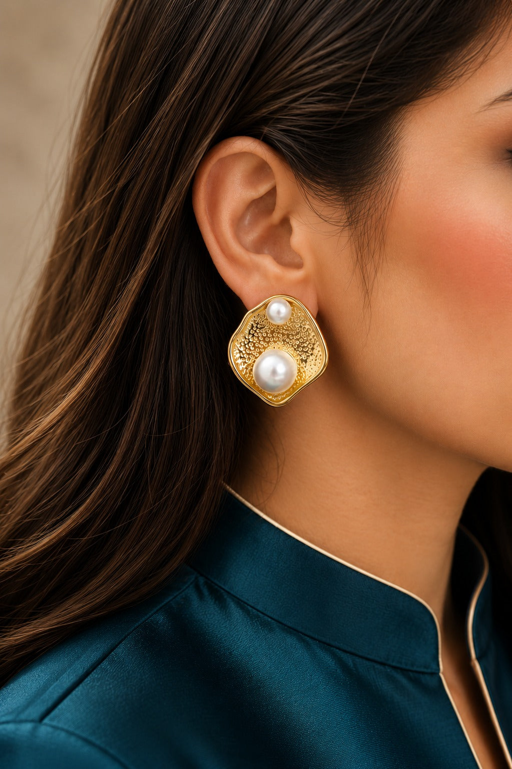 Model wearing organic textured gold stud earrings with dual pearl accents, showcasing contemporary statement earrings for formal and everyday styling.