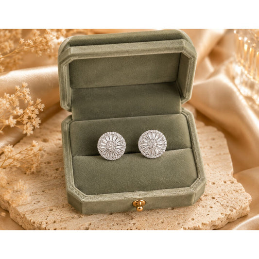 Silver-tone halo crystal stud earrings displayed inside a premium sage green velvet jewelry box on a natural travertine stone surface with champagne satin and dried floral accents.