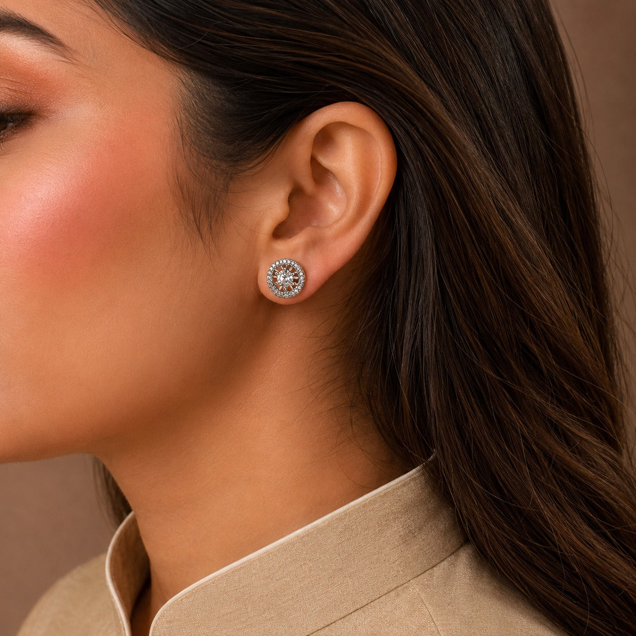 Close-up of a woman wearing a diamond earring with a neutral background