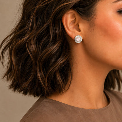 Blush pink halo gemstone stud earrings worn on model with silver-tone crystal halo design.