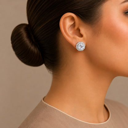 Close-up of a woman wearing a silver/ clear earring with a neutral background