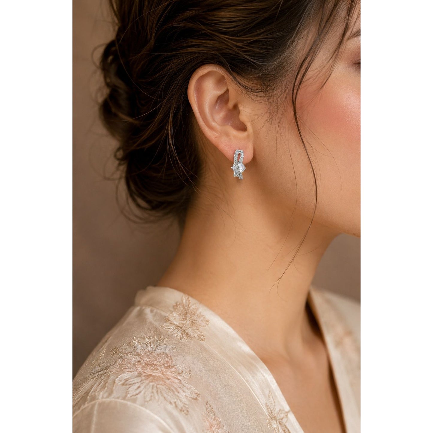 Woman wearing silver infinity crystal hoop earrings with marquise-cut center stone, premium cubic zirconia earrings for party and everyday wear.