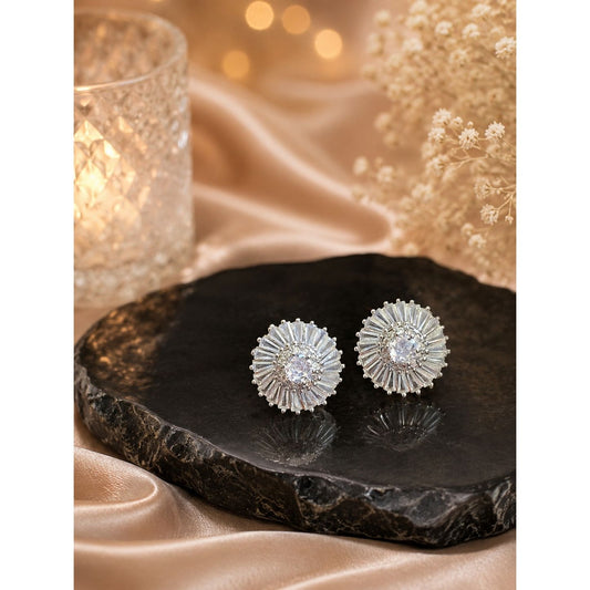 Silver halo crystal stud earrings featuring a round center stone with baguette-cut cubic zirconia displayed on a premium black stone surface.
