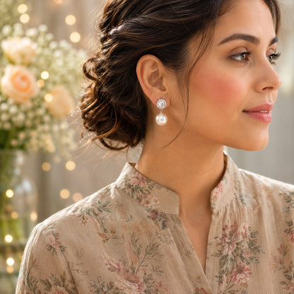 Close-up of a model wearing silver halo crystal pearl drop earrings with sparkling round crystals and luminous pearl drops.