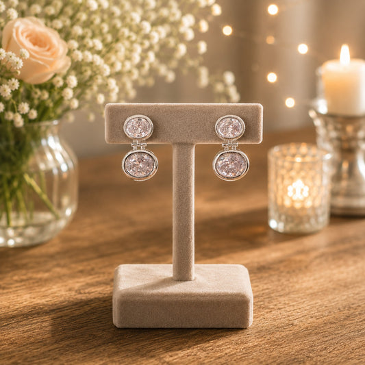 Silver double halo drop earrings with clear/silver crystals displayed on a premium beige velvet jewellery stand.