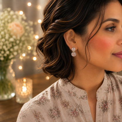 Model wearing silver double halo drop earrings featuring sparkling clear crystals.
