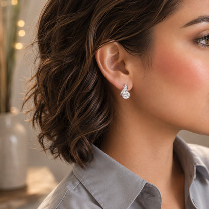 Close-up of a model wearing silver twist solitaire crystal stud earrings featuring a brilliant round centre stone and pavé detailing