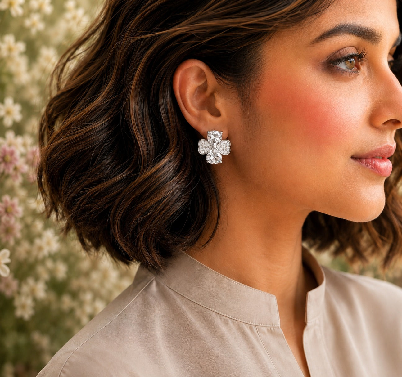 Model wearing silver crystal bow stud earrings with clear heart-cut crystals and pavé detailing.