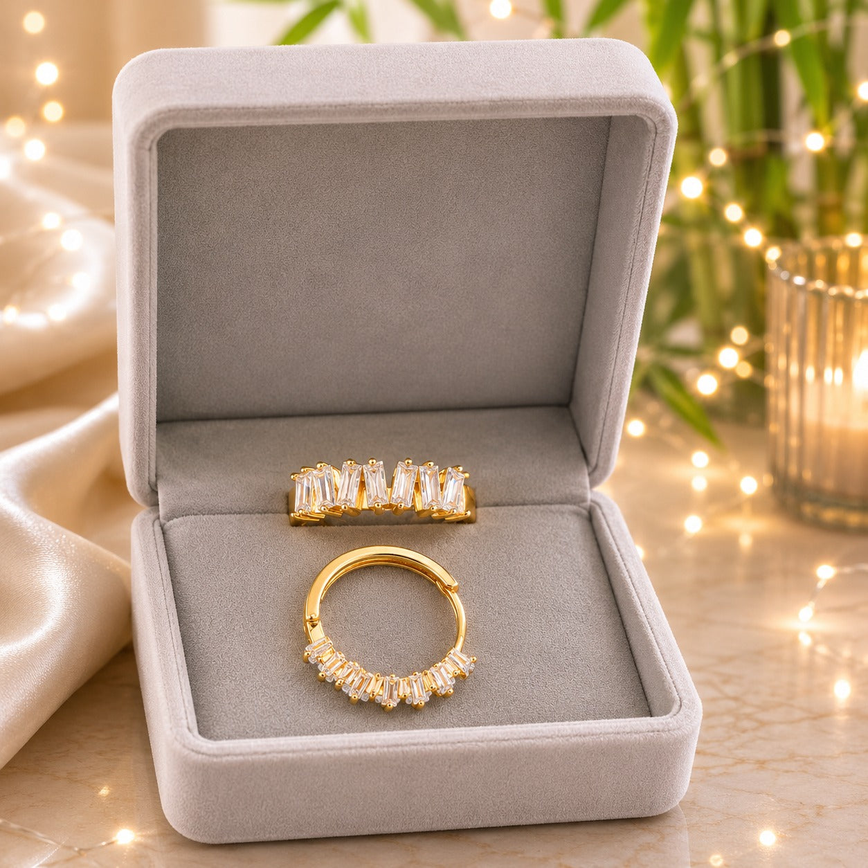 Gold baguette crystal hoop earrings displayed inside a premium light grey velvet jewellery box.