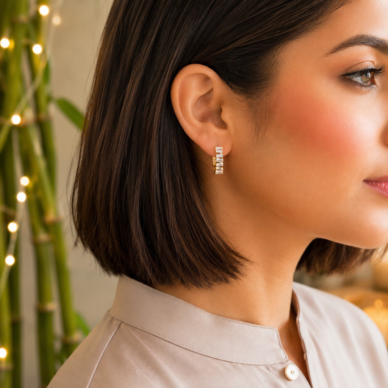 
Model wearing premium gold baguette crystal hoop earrings with sparkling rectangular-cut stones.