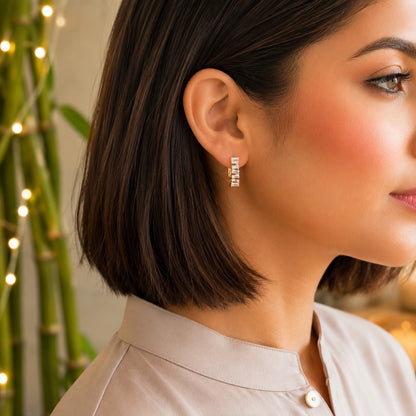 
Model wearing premium gold baguette crystal hoop earrings with sparkling rectangular-cut stones.