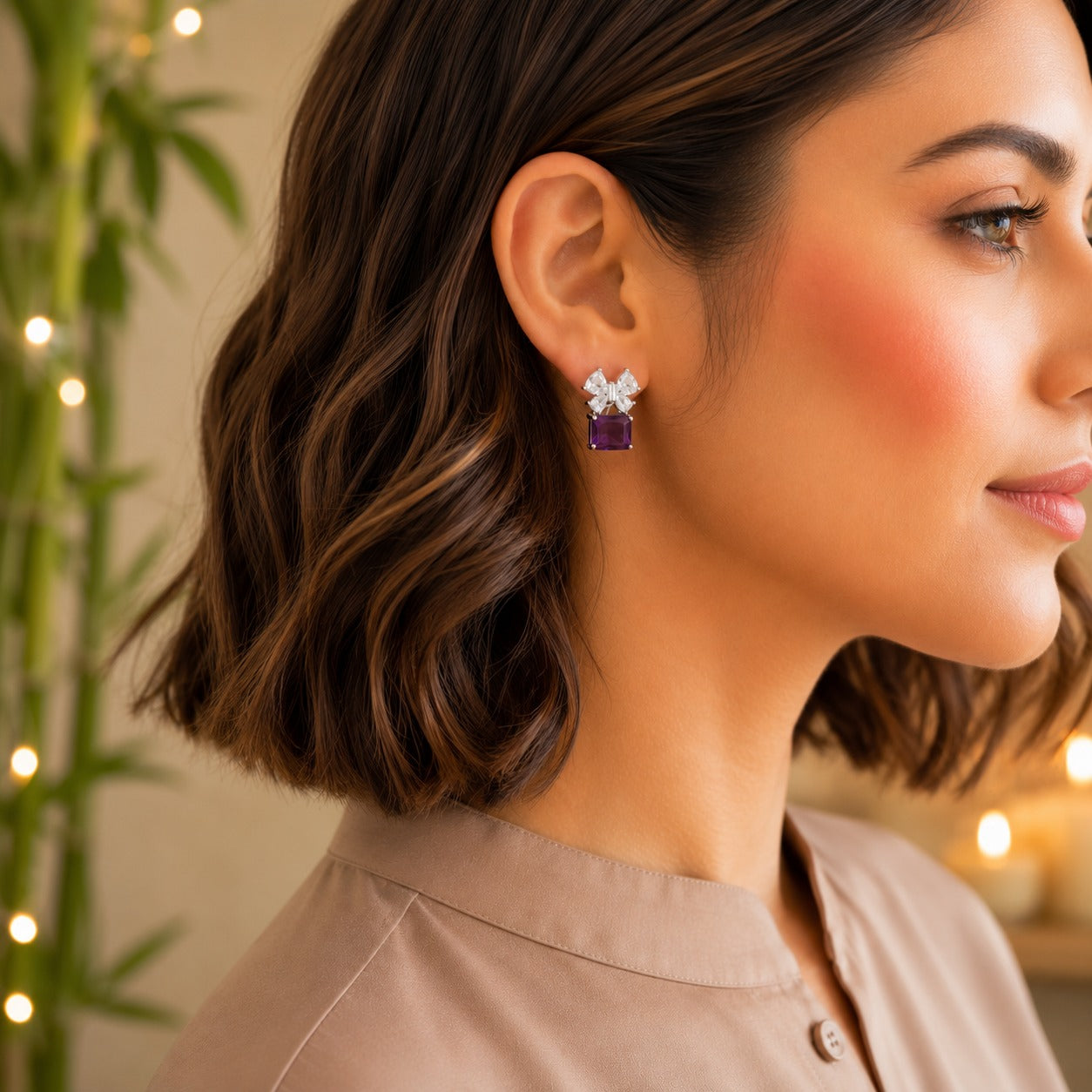 Model wearing floral crystal stud earrings with a royal purple emerald-cut gemstone drop.
