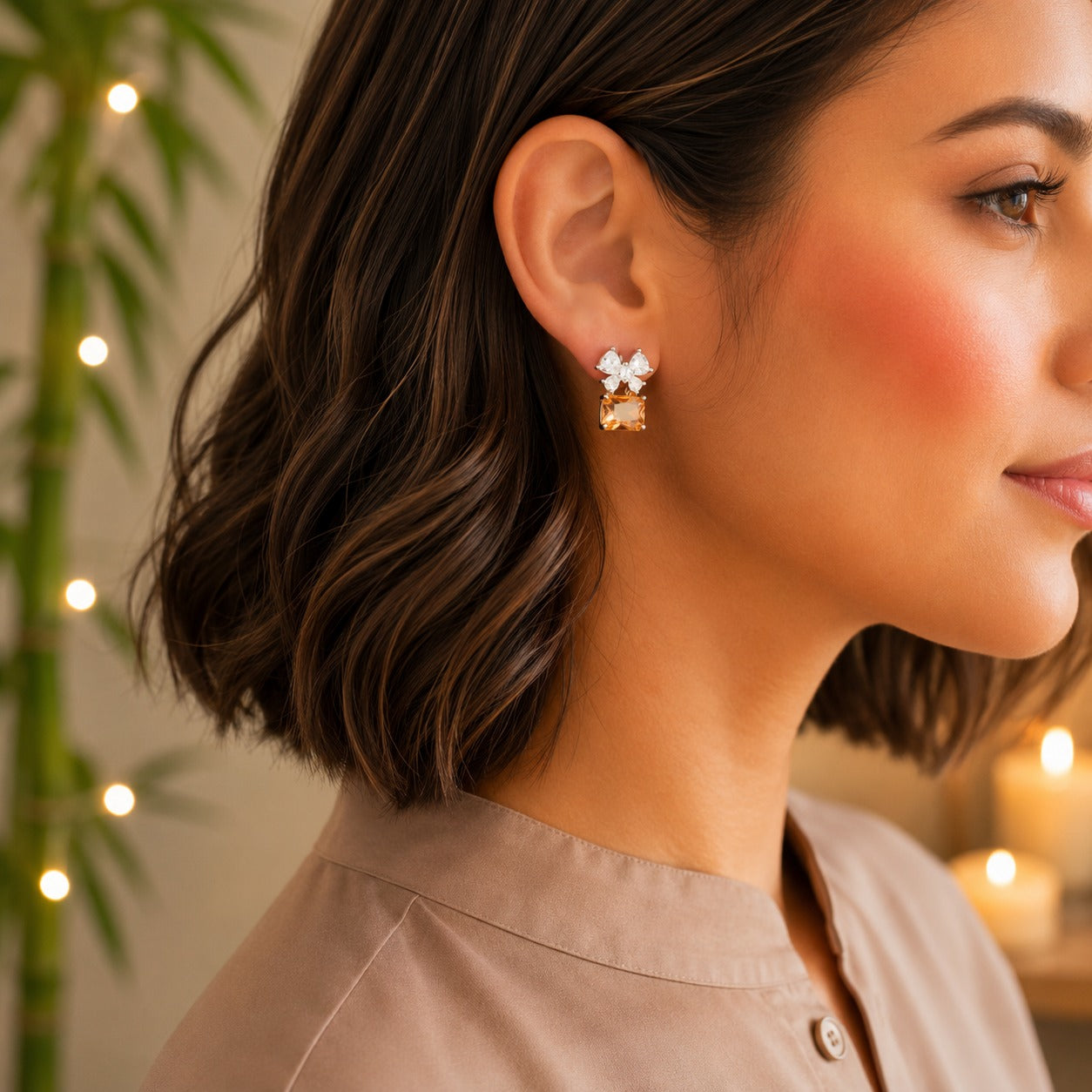 Model wearing floral crystal stud earrings with a champagne emerald-cut gemstone drop.