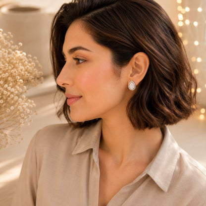 Woman wearing luxury silver teardrop crystal stud earrings with pavé halo in a side profile portrait, showcasing premium everyday jeweller