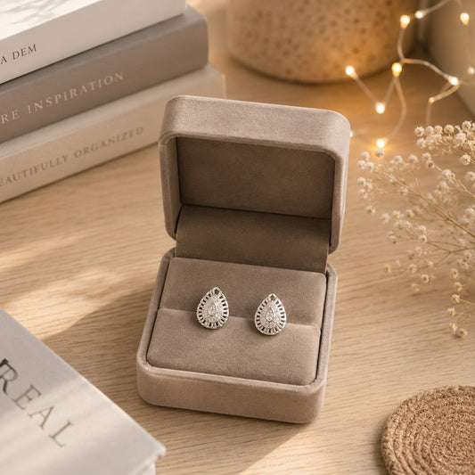 Luxury silver teardrop crystal stud earrings displayed in a premium taupe velvet jewellery box with sparkling pavé stones.