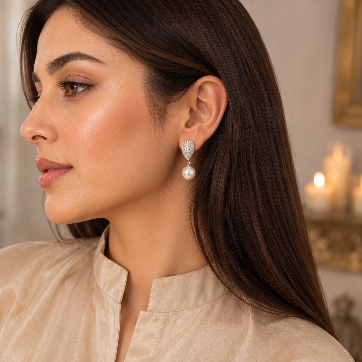Woman wearing elegant silver pavé crystal teardrop earrings with a classic pearl drop in a luxury side-profile portrait.