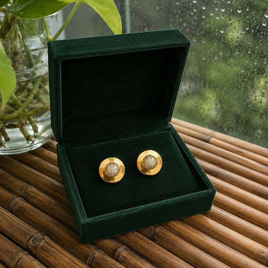 Round gold crystal disc stud earrings in a premium jewelry box, showcasing the polished metal finish and sparkling crystal center