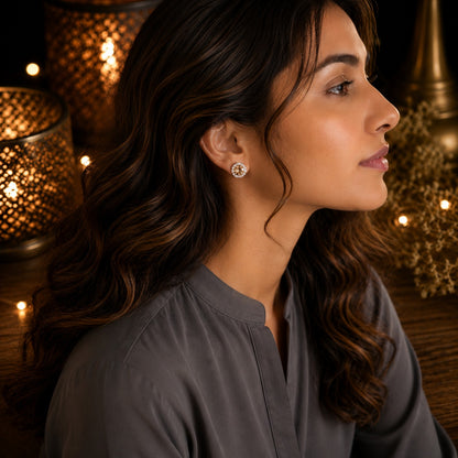Model wearing round halo crystal stud earrings with a sparkling champagne center stone and crystal border in a side-profile portrait.