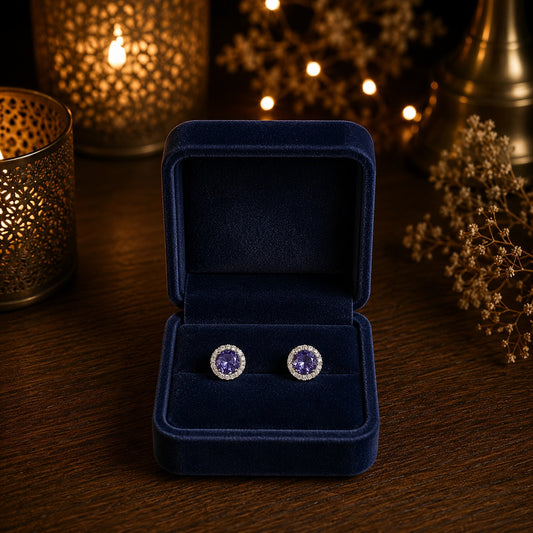 Round halo crystal stud earrings with a faceted  purple center stone displayed in a premium navy velvet jewellery box.