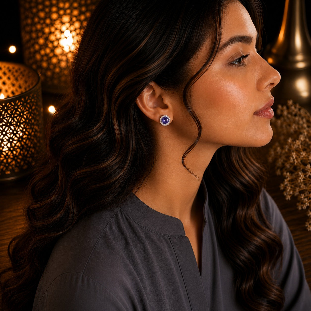 Model wearing round halo crystal stud earrings with a sparkling purple center stone and crystal border in a side-profile portrait