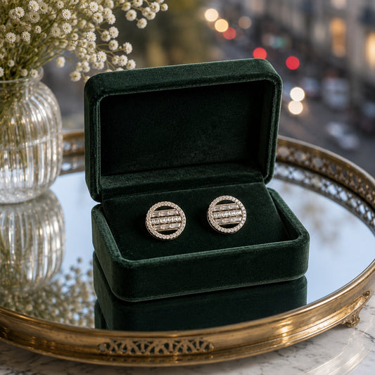 Round geometric crystal disc stud earrings displayed inside a premium dark green velvet jewellery box on a mirrored tray.