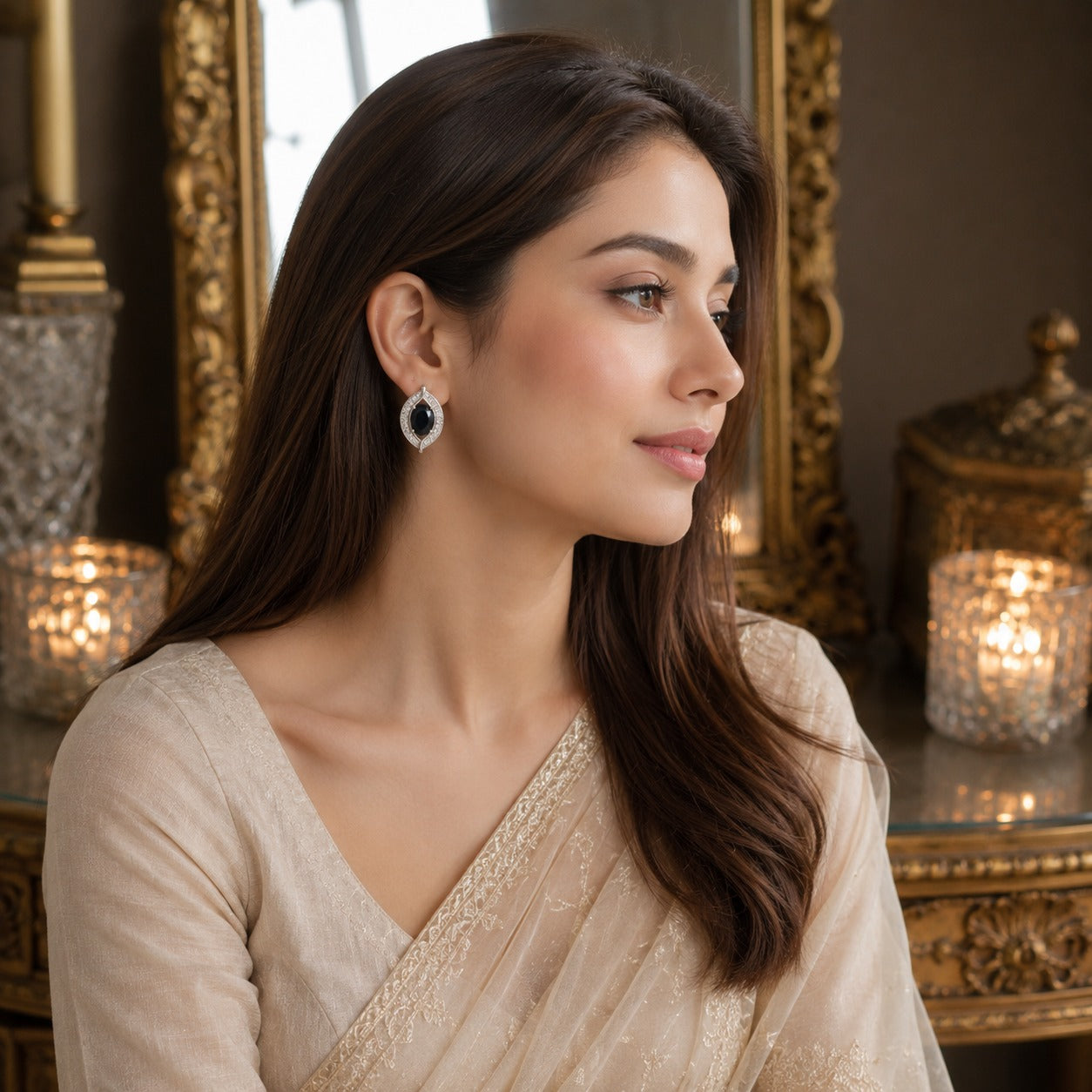 Woman wearing elegant black oval gemstone crystal halo latch-back earrings with a cream embroidered outfit in a luxury vintage setting