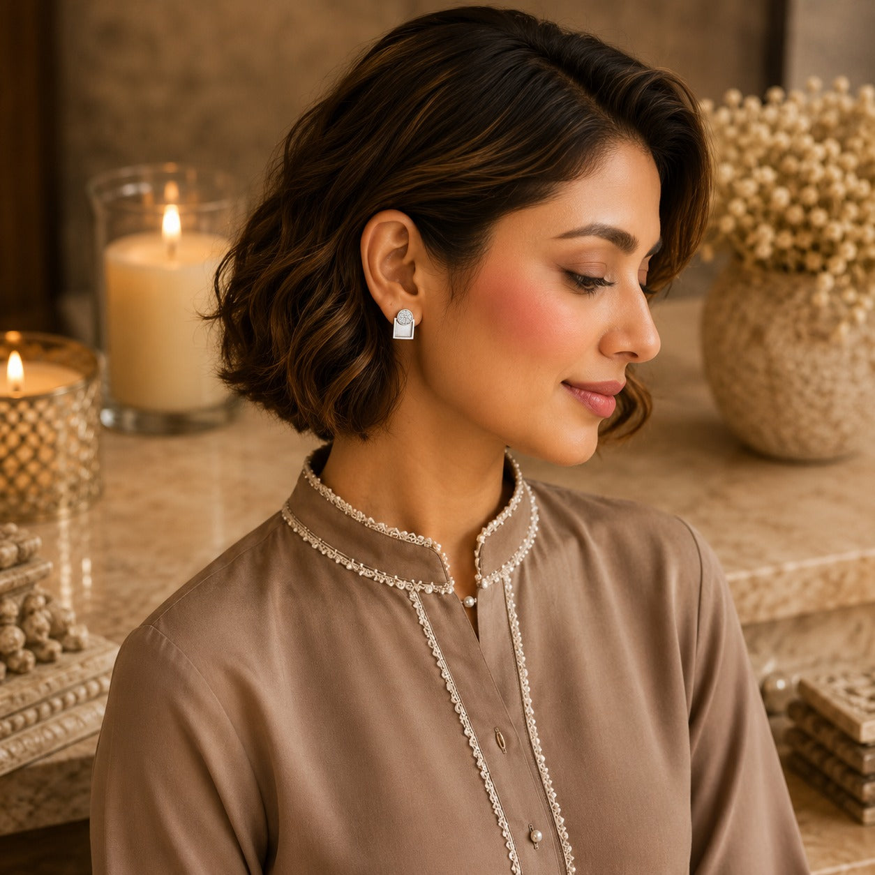 Woman wearing silver geometric mother of pearl zircon stud earrings with a taupe embroidered kurta in a luxury indoor setting, showcasing modern everyday jewellery.