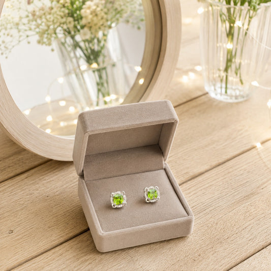 Peridot green square halo stud earrings presented in a premium velvet jewellery box with a luxury vanity settin