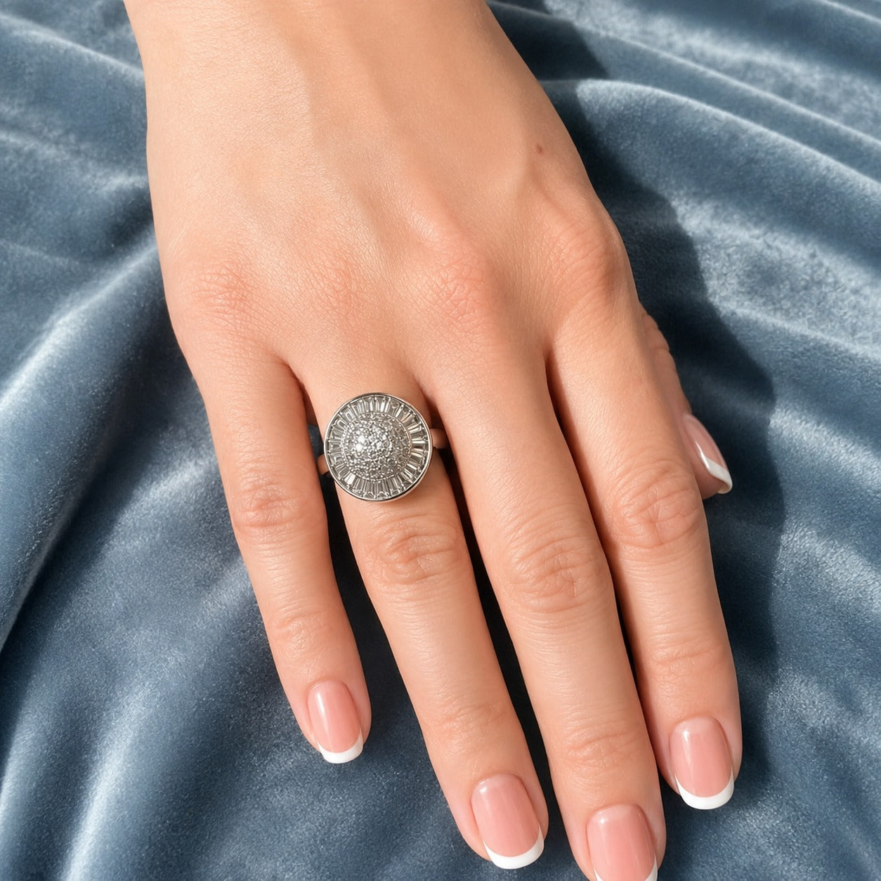 Silver sunburst statement ring worn on a woman's hand featuring a textured circular dome design with a contemporary polished finish.