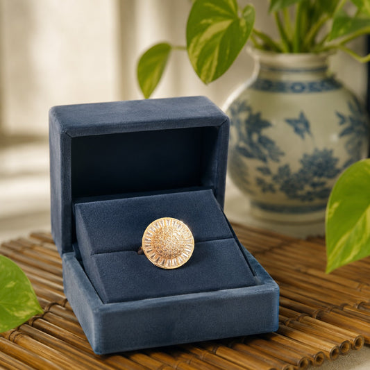 Gold sunburst statement ring presented inside a premium navy velvet jewellery box in an elegant luxury display.