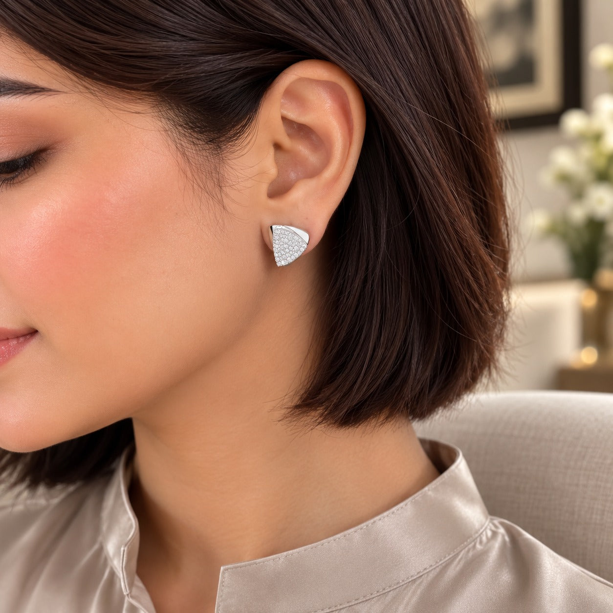 Model wearing elegant silver geometric triangular pavé crystal stud earrings in a sophisticated luxury setting.