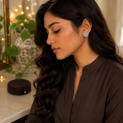 Model wearing Daybreak silver crystal stud earrings with a sparkling pavé centre and sunburst-inspired circular design by TIAS Collection.