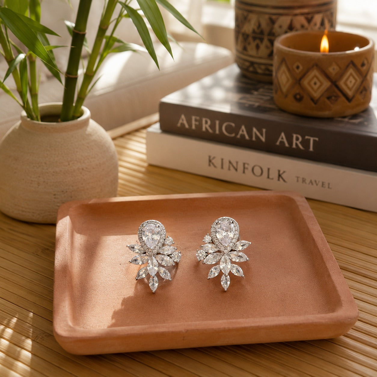 First Light silver crystal stud earrings with a pear-cut centre stone and marquise crystal design displayed on a premium terracotta ceramic tray by TIAS Collection.