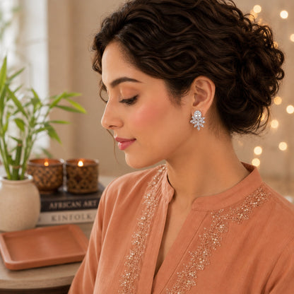 Model wearing First Light silver crystal stud earrings featuring a pear-cut halo and radiant marquise crystal design by TIAS Collection.