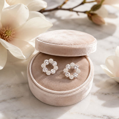 Silver floral halo stud earrings featuring faceted clear crystals and pavé accents with butterfly stopper back
