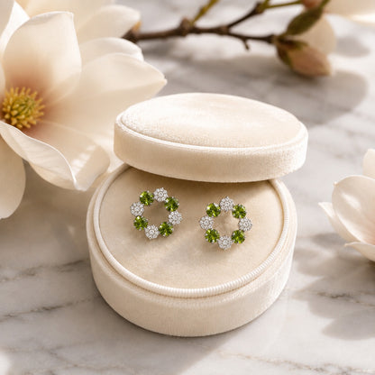 Silver floral halo stud earrings featuring faceted olive green crystals and pavé accents with butterfly stopper back