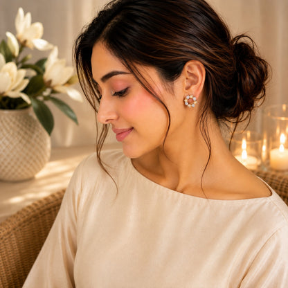 Woman wearing silver beige floral halo stud earrings with faceted champagne stones and butterfly stopper back in a warm luxury portrait