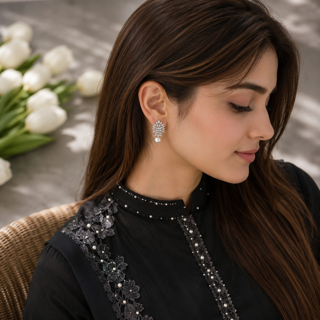 Model wearing silver marquise crystal earrings with pearl drops in a soft side-profile portrait with natural daylight.