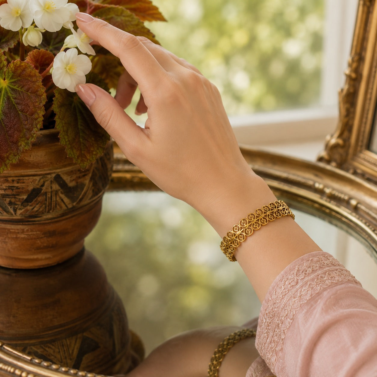 Model wearing a gold openwork bracelet with a front magnetic clasp on a slender wrist in a soft natural daylight setting.