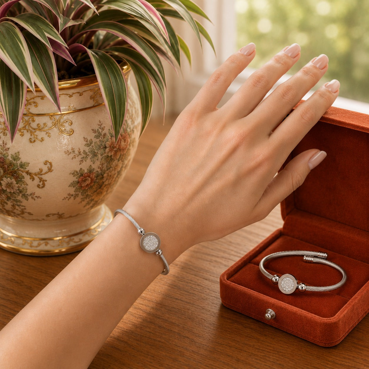 Model wearing a silver twisted cable bracelet with a crystal pavé centerpiece on the wrist in a warm natural daylight setting.