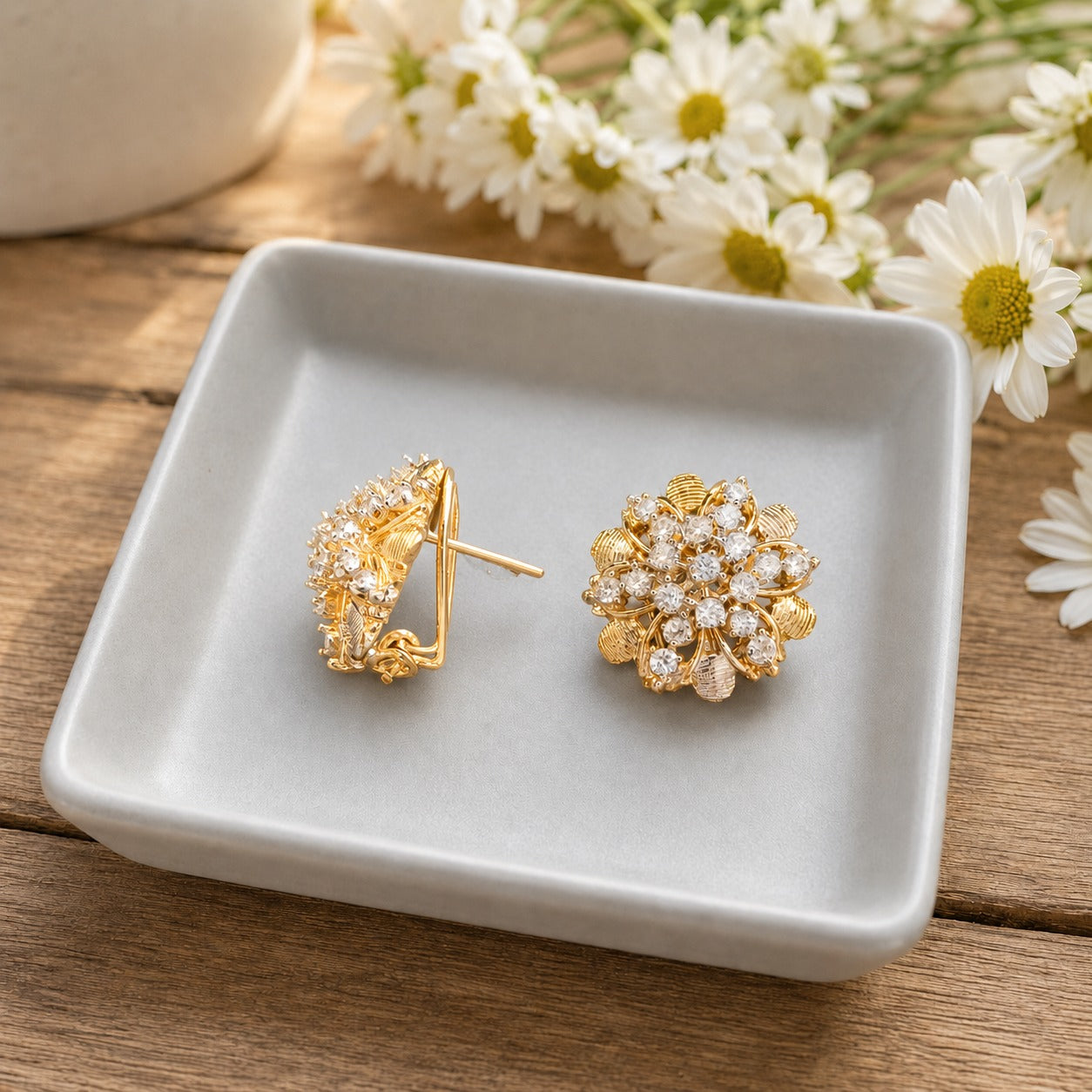 Side view of gold floral crystal stud earrings showing the secure clip-on comfort closure and layered floral design.