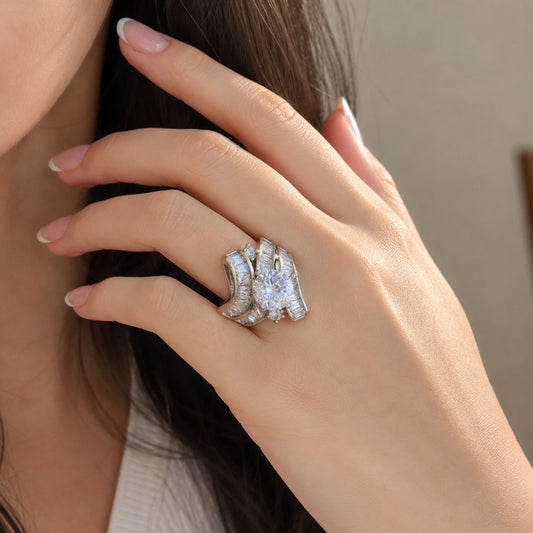 S925 sterling silver statement ring worn on the finger, featuring a sparkling round center stone and layered baguette zircon detailing.