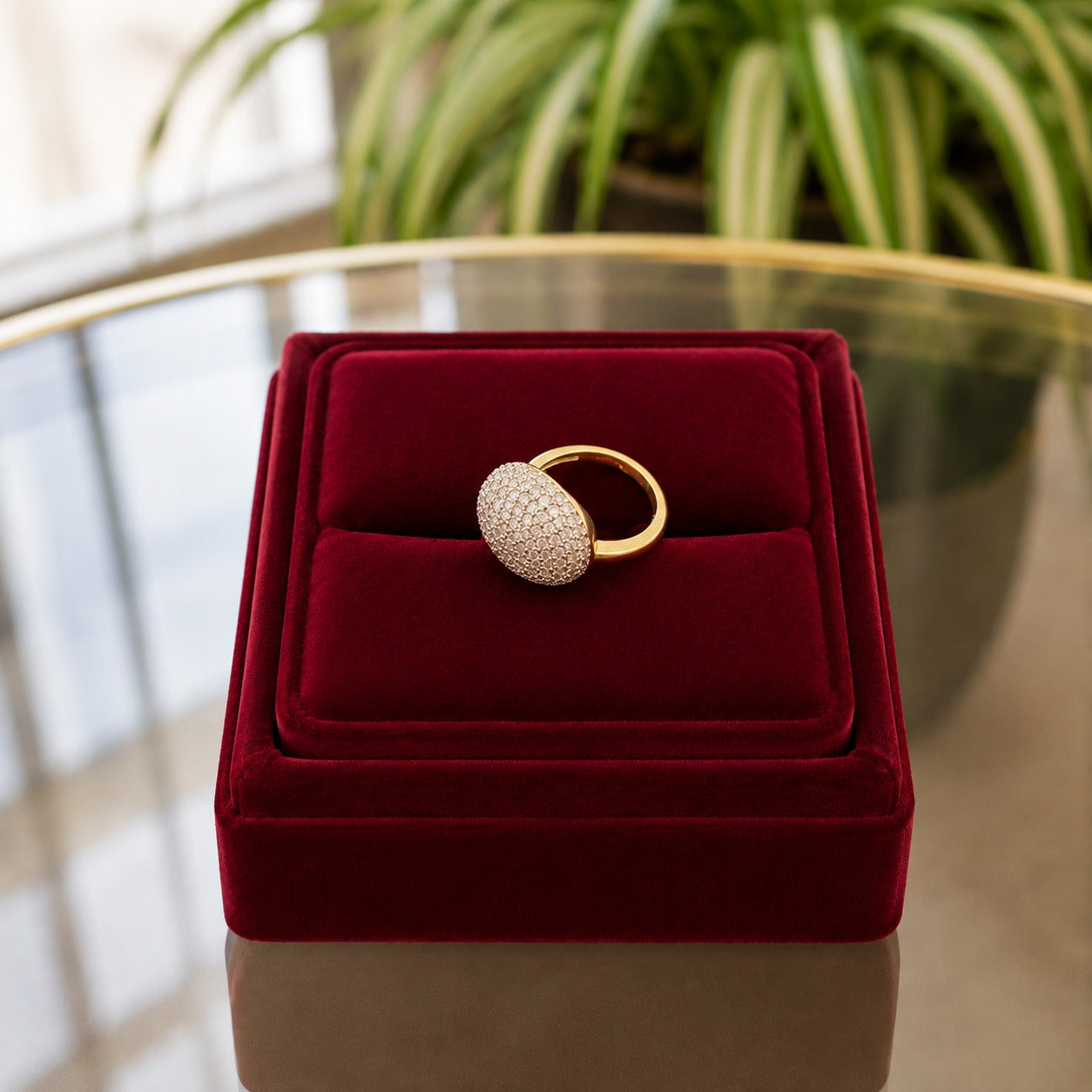 Side-angle view of a pavé dome ring displayed on a deep burgundy velvet ring stand with a softly blurred indoor background