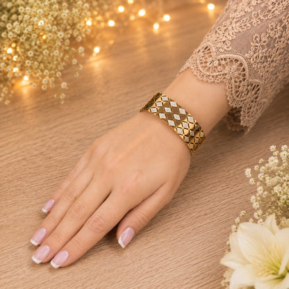 Gold-tone lattice lock cuff bracelet worn on a smaller wrist, showcasing its structured fit and geometric crystal pattern