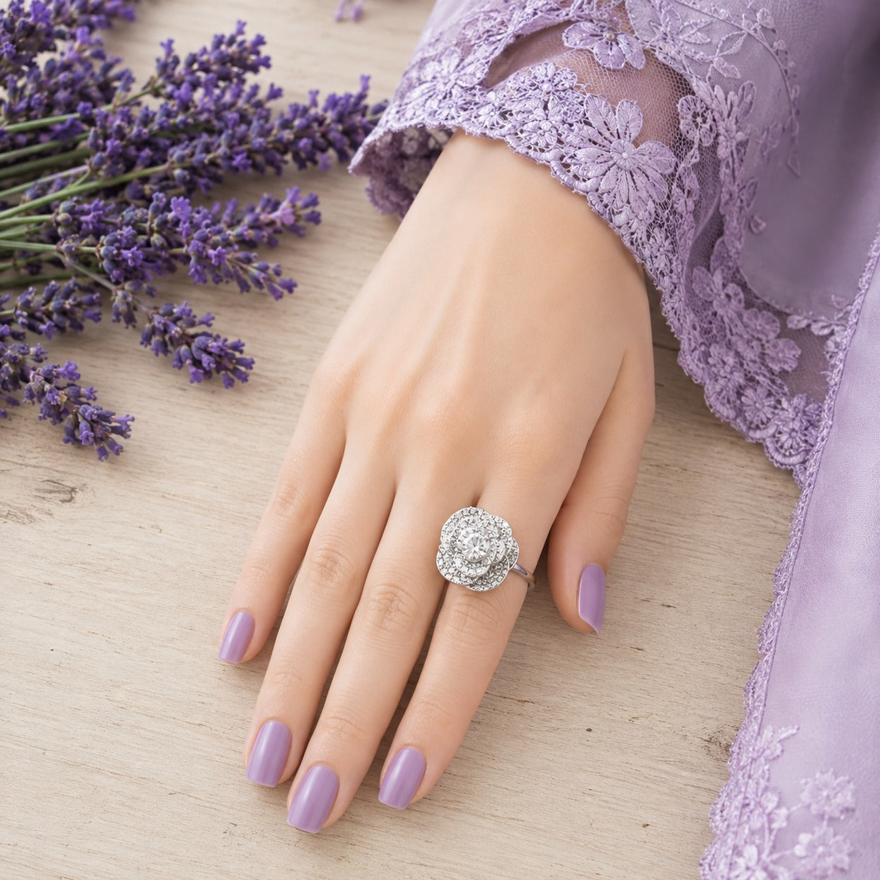 Model wearing an S925 sterling silver floral halo ring with a layered zircon flower design, paired with a lavender lace sleeve and soft lavender manicure