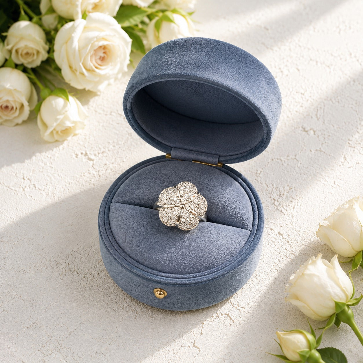 Floral crystal ring displayed inside a premium blue velvet jewellery box with white roses.