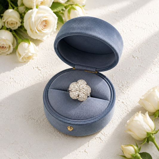 Floral crystal ring displayed inside a premium blue velvet jewellery box with white roses.