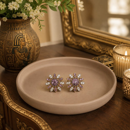 Lavender floral crystal stud earrings displayed on a premium neutral display tray with warm luxury décor